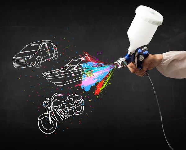 Mann mit Airbrush-Sprühfarbe mit Auto-, Boots- und Motorradzeichnung — Stockfoto