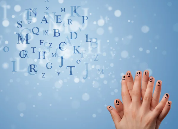 Happy smiley fingers looking at mixture of bokeh letters — Stock Photo, Image