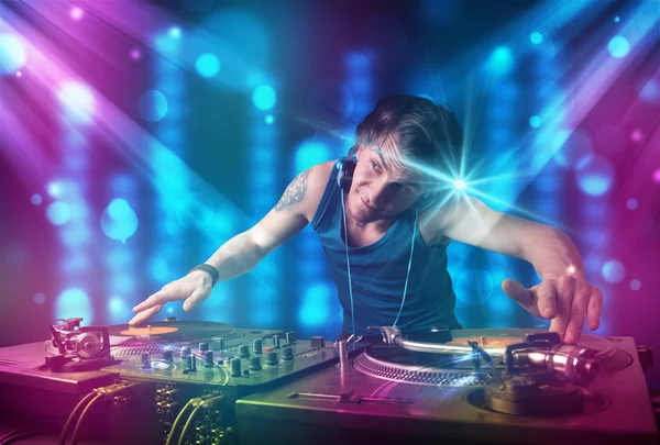 Dj mixing music in a club with blue and purple lights — Stock Photo, Image