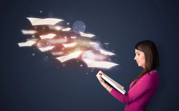 Young lady reading a book with flying sheets coming out of the b — Stockfoto