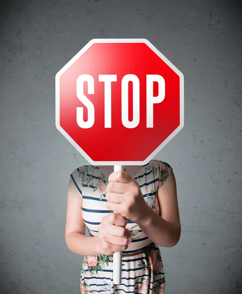 Mujer joven sosteniendo una señal de stop — Foto de Stock