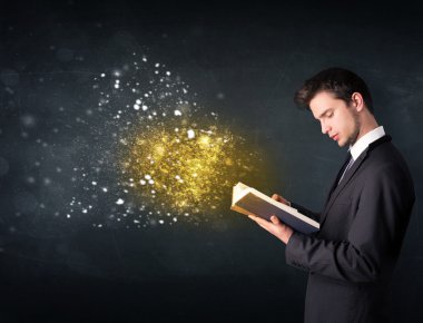 Genç adam sihirli bir kitap okuyor.