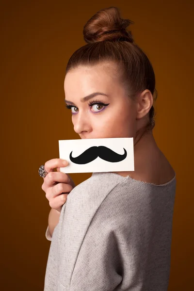 Happy cute girl holding paper with mustache drawing — Stock Photo, Image