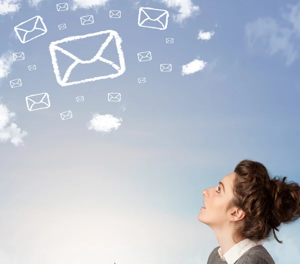 Chica joven mirando el símbolo de correo nubes en el cielo azul —  Fotos de Stock