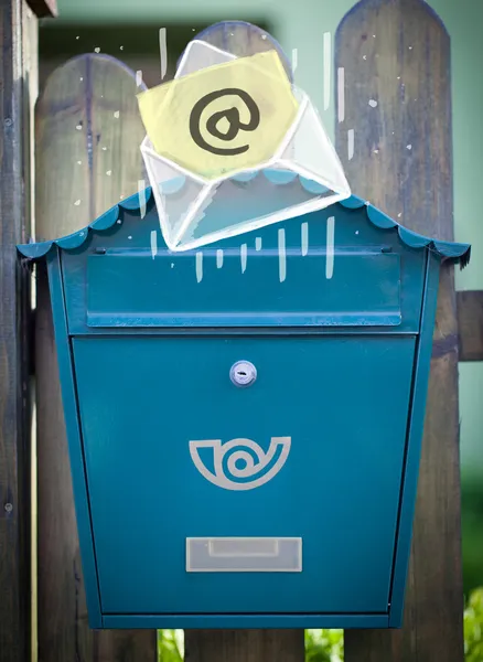 Envelope with email sign dropping into mailbox — Stock Photo, Image