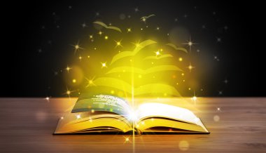 Altından parlak uçan kağıt sayfaları olan açık bir kitap