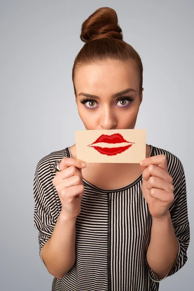 Feliz bonita mujer sosteniendo tarjeta con marca de lápiz labial beso —  Fotos de Stock