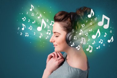 Kulaklıklı genç bir kadın müzik dinliyor.