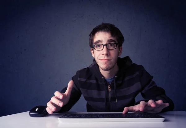 Hacker trabalhando com teclado em fundo azul — Fotografia de Stock