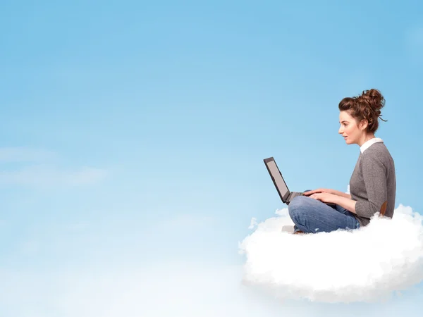 Young woman with laptop sitting on cloud with copy space — Stock Photo, Image