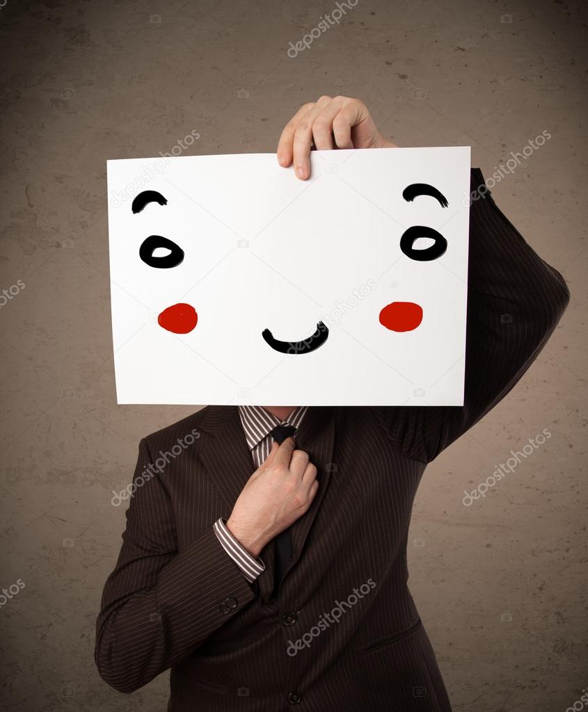 Businessman holding a cardboard with a smiley face on it