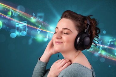 Kulaklıkla müzik dinleyen genç bir kadın.