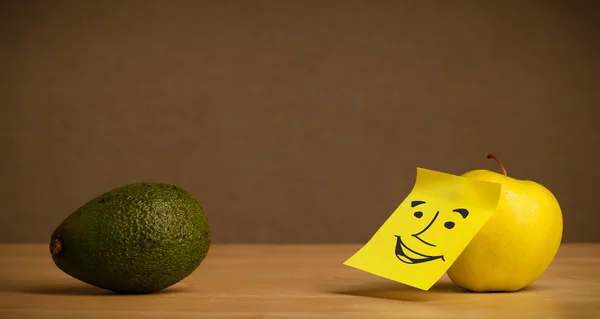 Apple with post-it note smiling at avocado — Stock Photo, Image