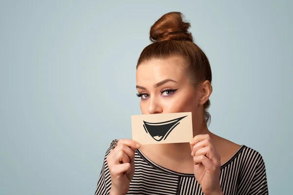 Feliz linda chica sosteniendo papel con divertido dibujo sonriente —  Fotos de Stock