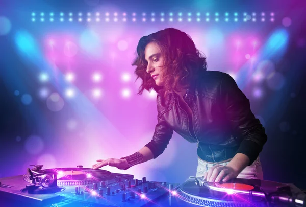 Disc jockey mixen van muziek op de draaitafels op het podium met lichten en — Stockfoto
