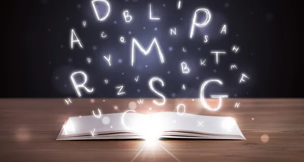Open boek met gloeiende letters vliegen uit — Stockfoto