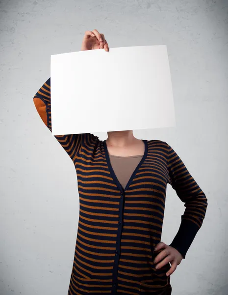Woman holding in front of her head a paper with copy space — Stock Photo, Image
