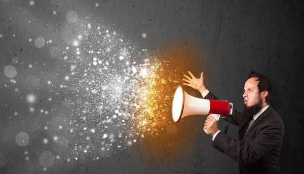 Guy shouting into megaphone and glowing energy particles explode