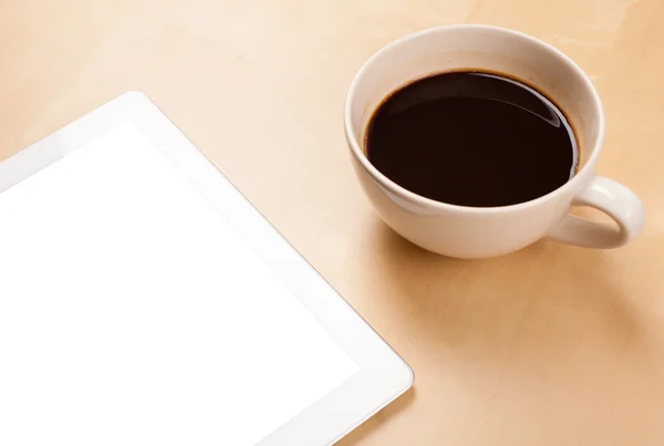 Tablet pc com espaço vazio e uma xícara de café em uma mesa — Fotografia de Stock