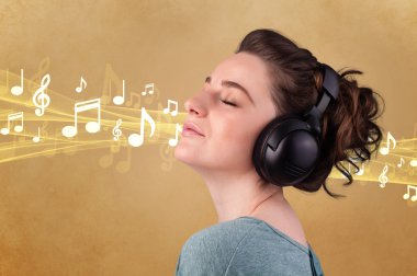 Kulaklıklı genç bir kadın müzik dinliyor.