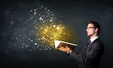 Genç adam sihirli bir kitap okuyor.