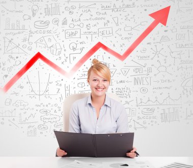 Piyasa diyagramlarıyla masada oturan iş kadını.