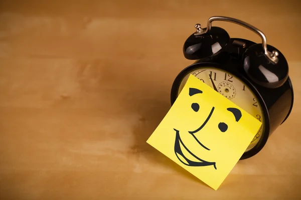 Post-it note avec le visage souriant collé sur une horloge — Photo