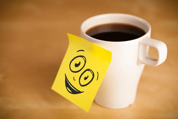 Post-it note avec le visage souriant collé sur la tasse — Photo
