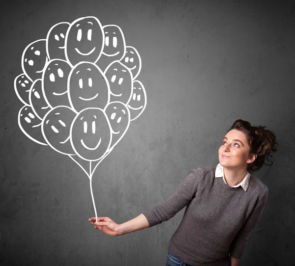 Woman holding a bunch of smiling balloons — Stock Photo, Image