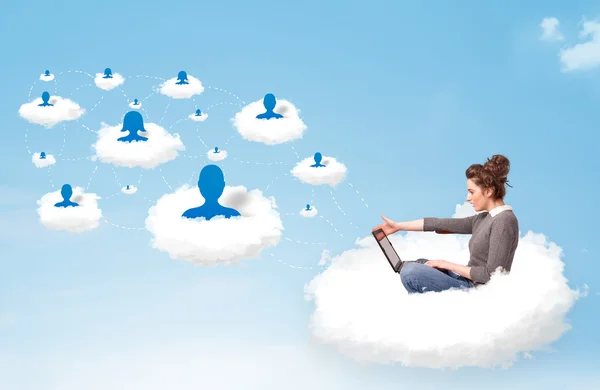 Young woman sitting in cloud with laptop — Stock Photo, Image