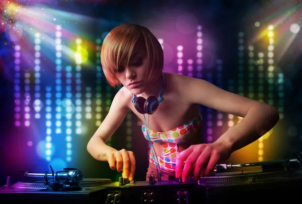 Chica Dj tocando canciones en una discoteca con espectáculo de luz — Foto de Stock