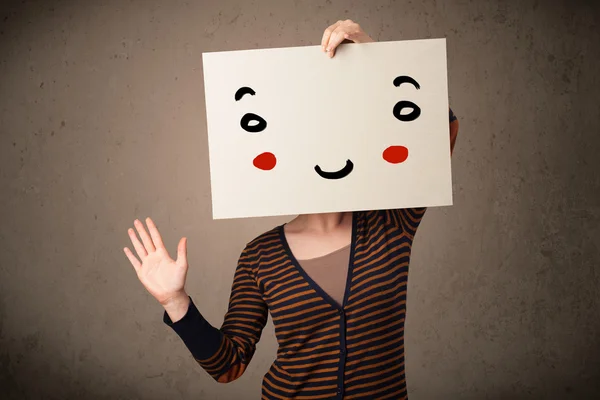 Woman holding a cardboard with a smiley face on it — Stock Photo, Image