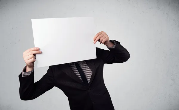 Homme d'affaires tenant devant sa tête un papier avec espace de copie — Photo