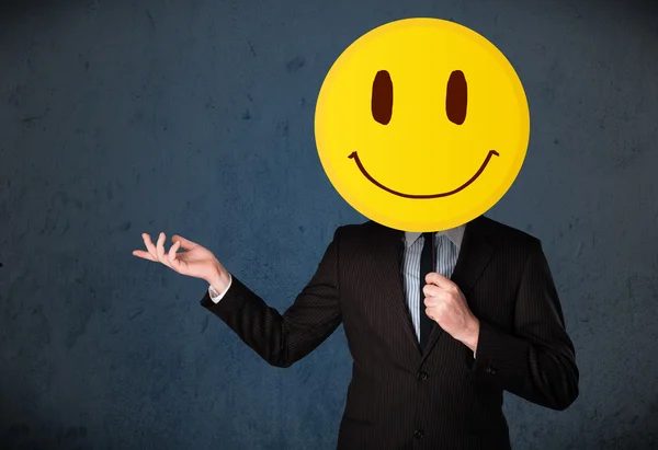 Üzletember kezében egy mosolygós arc emotikon — Stock Fotó