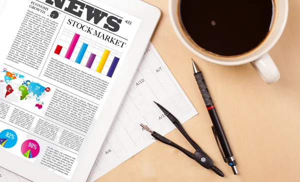 Tablet pc shows news on screen with a cup of coffee on a desk — Stock Photo, Image