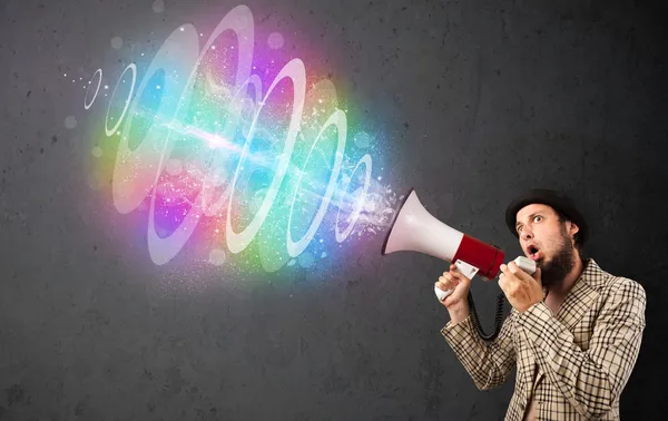 Man yells into a loudspeaker and colorful energy beam comes out — Stock Photo, Image