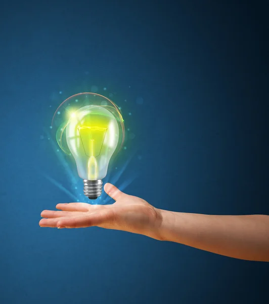 Glowing lightbulb in the hand of a woman — Stock Photo, Image