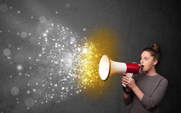Женщина кричит в мегафон и исследует светящиеся частицы энергии
