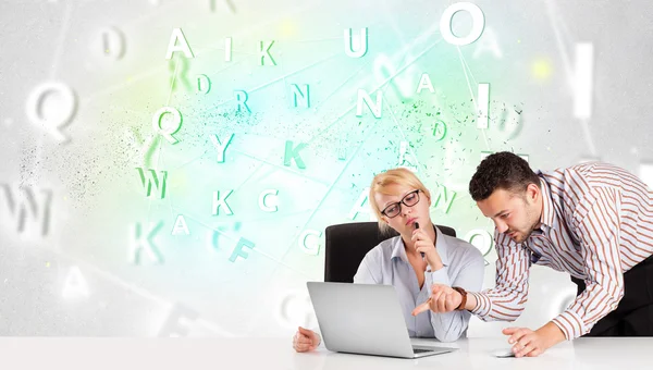 Business people at desk with green word cloud — Stock Photo, Image