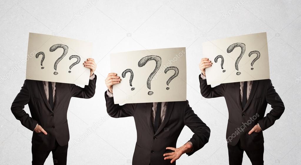 Confused men in formal gesturing with question marks on cardboar