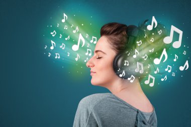 Kulaklıklı genç bir kadın müzik dinliyor.