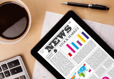 Tablet bilgisayarı haberleri ekranda bir fincan kahveyle sunar.