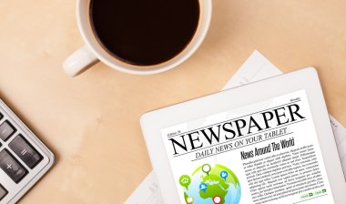Tablet bilgisayarı haberleri ekranda bir fincan kahveyle sunar.