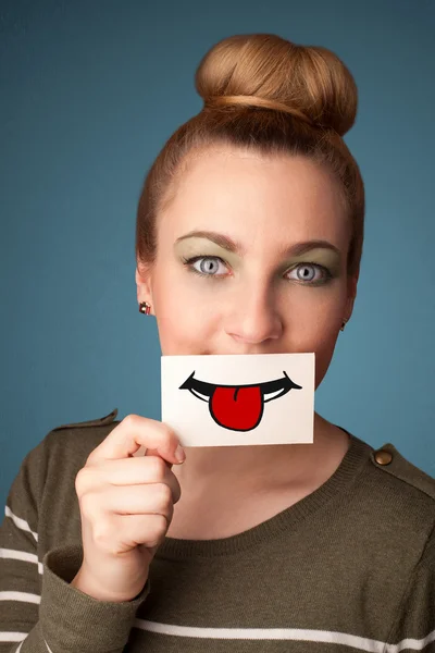 Feliz bonita mujer sosteniendo tarjeta con divertido smiley — Foto de Stock