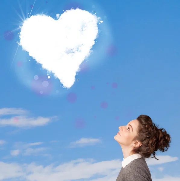 Jolie fille regardant le nuage de coeur blanc sur le ciel bleu — Photo