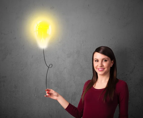 Woman holding a lightbulb balloon — Stock Photo, Image