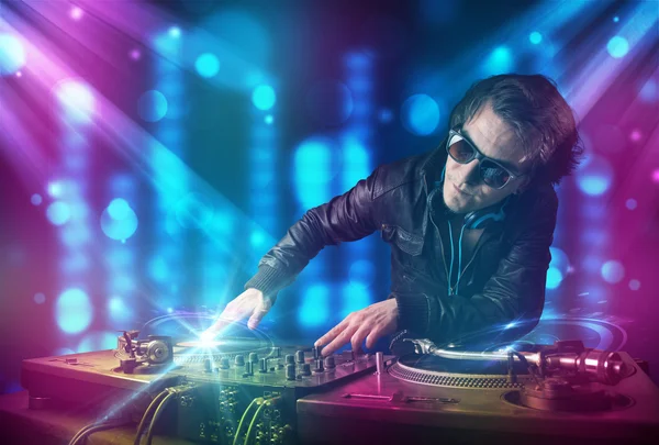 Dj mezclando música en un club con luces azules y moradas — Foto de Stock