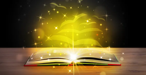 Open book with golden glow flying paper pages — Stock Photo, Image