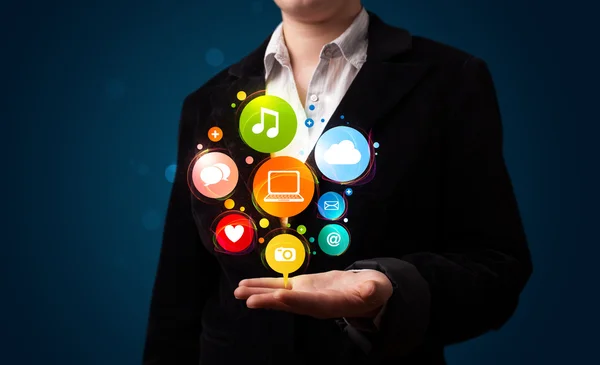 Young woman presenting colorful technology icons and symbols — Stock Photo, Image