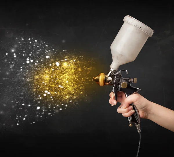 Trabajador con pintura de aerógrafo con pintura dorada brillante —  Fotos de Stock